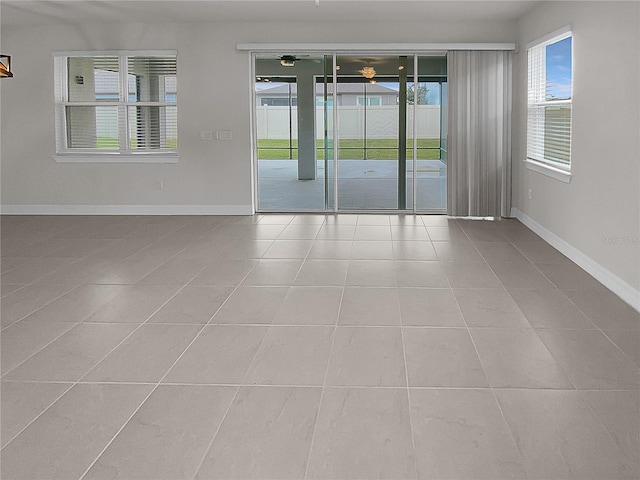 spare room with baseboards and tile patterned floors