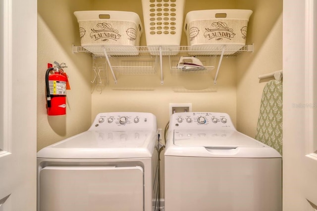 clothes washing area featuring laundry area and washer and clothes dryer