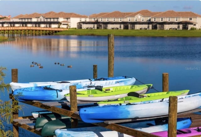 view of dock with a water view and a residential view