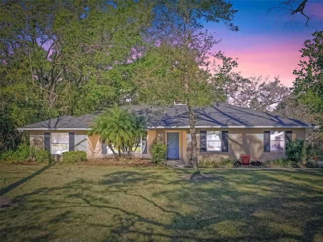 single story home featuring stucco siding and a front yard