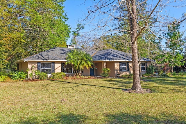 ranch-style house featuring stucco siding and a front lawn