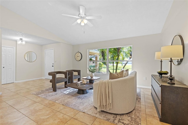 living room with lofted ceiling, light tile patterned floors, baseboards, and ceiling fan