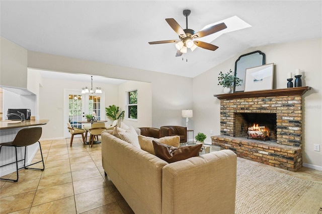 living room featuring a fireplace, light tile patterned floors, baseboards, ceiling fan, and vaulted ceiling