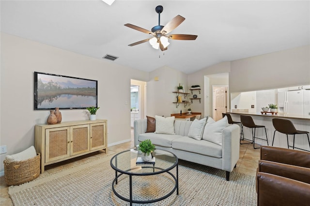 living room with visible vents, baseboards, vaulted ceiling, light tile patterned floors, and a ceiling fan