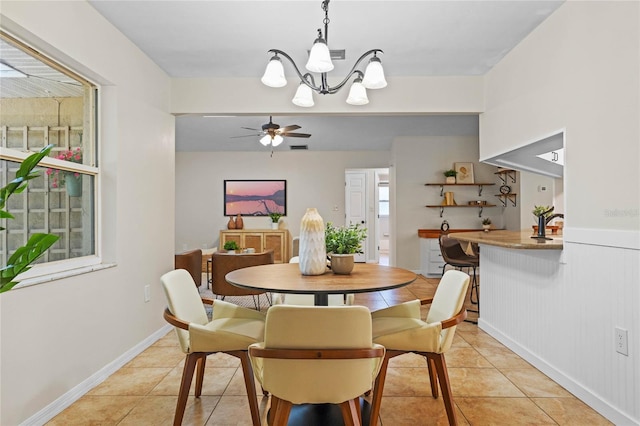 dining room featuring baseboards, light tile patterned flooring, and ceiling fan with notable chandelier