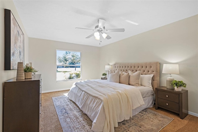 bedroom featuring ceiling fan, baseboards, and light carpet