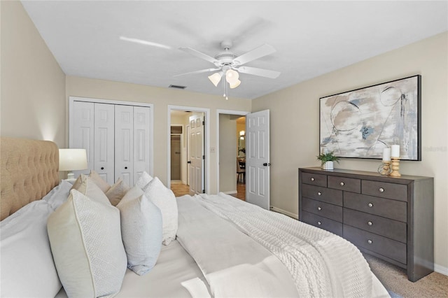 carpeted bedroom with visible vents, baseboards, a closet, and ceiling fan