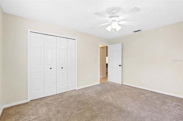 unfurnished bedroom with carpet flooring, baseboards, visible vents, and a closet