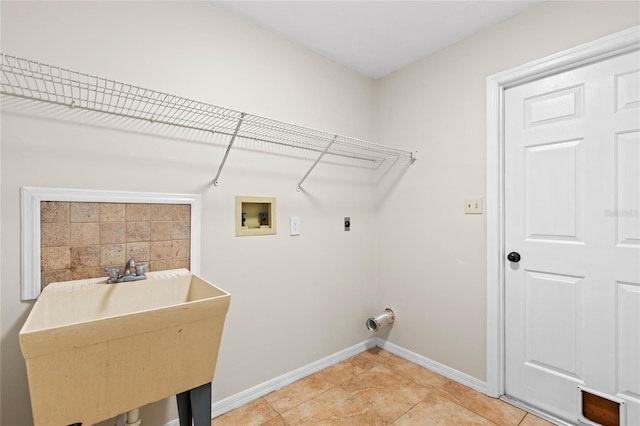 clothes washing area featuring a sink, baseboards, hookup for an electric dryer, hookup for a washing machine, and laundry area