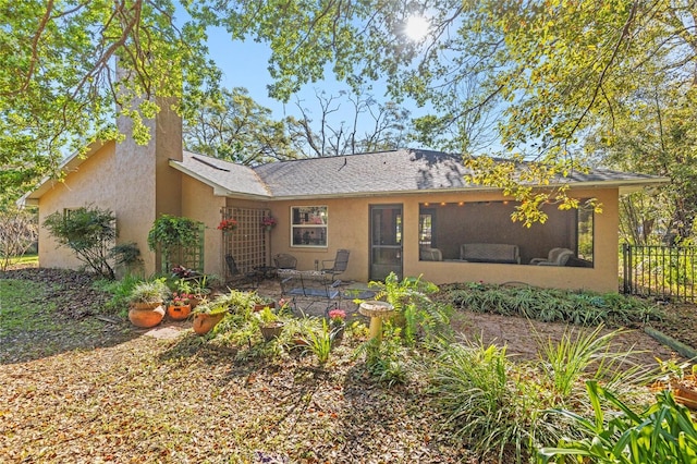 back of property with stucco siding, a patio, and fence