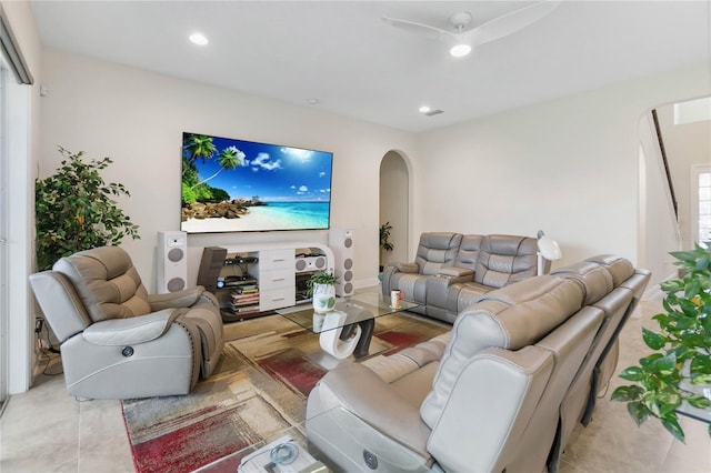 living area featuring a ceiling fan, arched walkways, light tile patterned floors, and recessed lighting