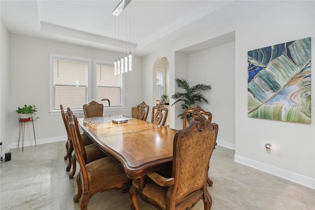 dining room with baseboards and arched walkways