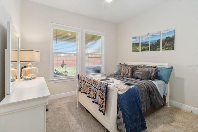 bedroom with baseboards and light colored carpet