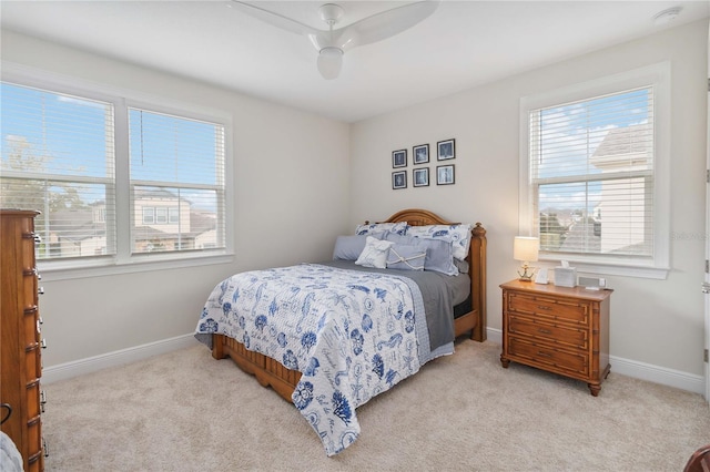 bedroom featuring a ceiling fan, light colored carpet, and baseboards