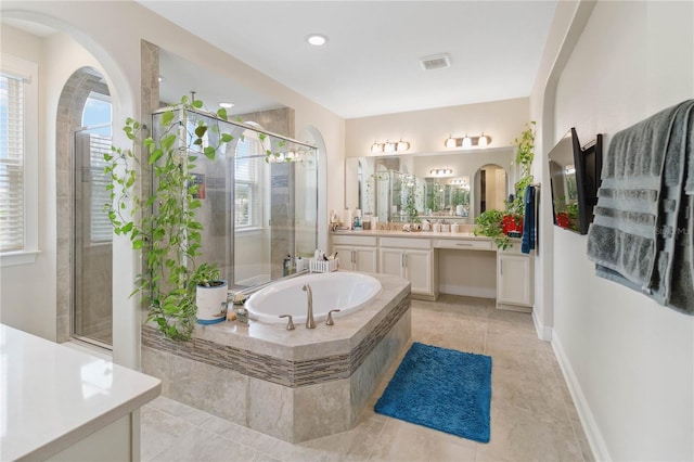 bathroom featuring a stall shower, baseboards, visible vents, a garden tub, and vanity