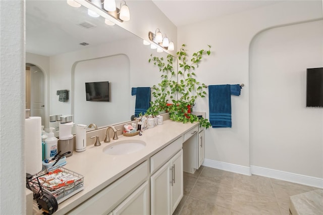 bathroom featuring tile patterned flooring, vanity, visible vents, and baseboards