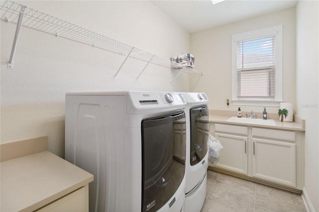 laundry room with light tile patterned floors, washer and clothes dryer, and a sink