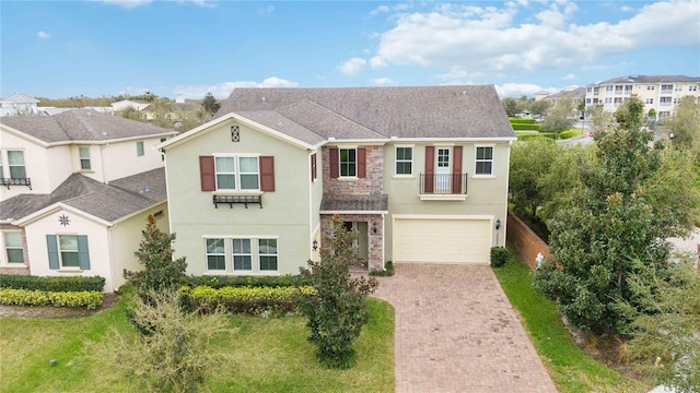 view of front of house featuring a garage, a front lawn, decorative driveway, and stucco siding