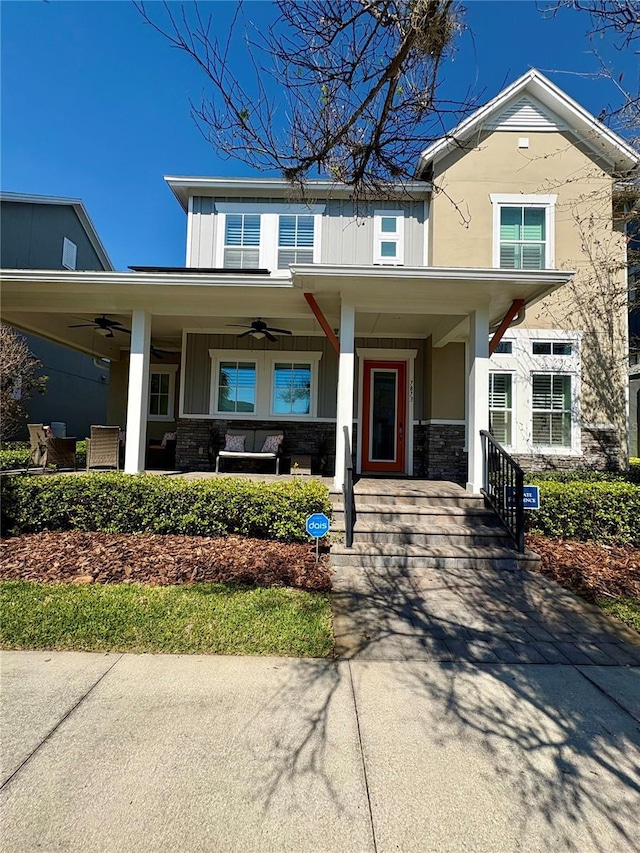 view of front of property featuring stone siding, ceiling fan, a porch, and board and batten siding