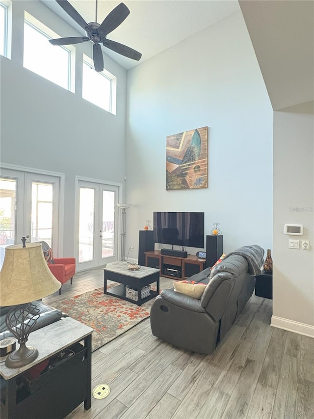 living area featuring a healthy amount of sunlight, light wood finished floors, and french doors