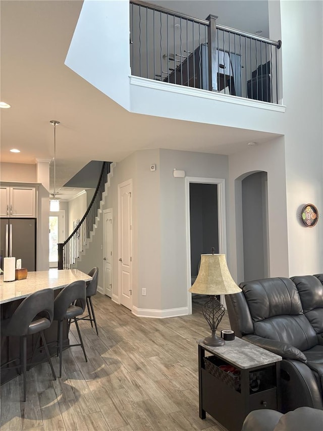 living area featuring stairway, recessed lighting, wood finished floors, and baseboards