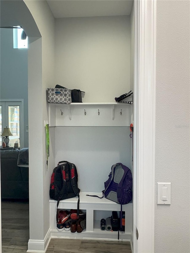 mudroom featuring arched walkways, wood finished floors, and french doors