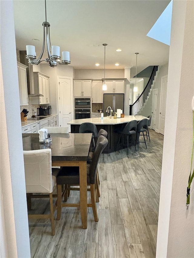 dining space with a chandelier, stairway, recessed lighting, and light wood-style floors