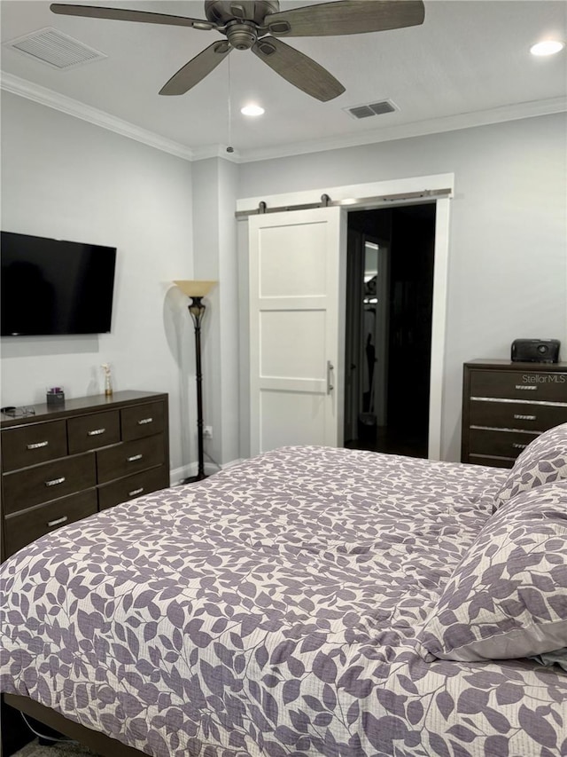 bedroom featuring ornamental molding, a barn door, visible vents, and recessed lighting