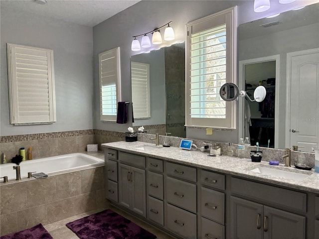 bathroom with a bath, plenty of natural light, and a sink