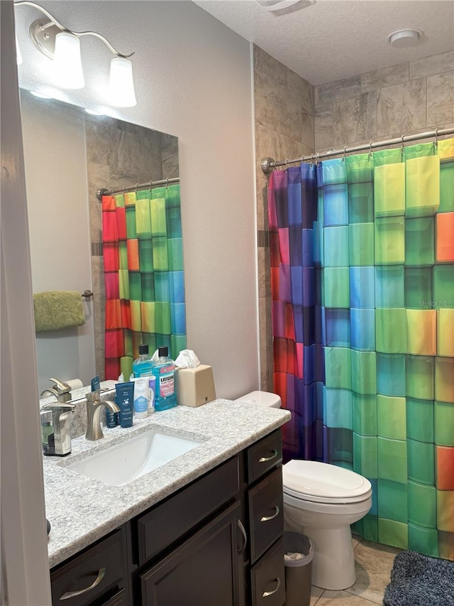 full bathroom with a shower with curtain, vanity, toilet, and a textured ceiling