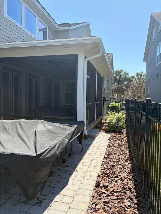 view of side of property featuring a sunroom and a fenced backyard