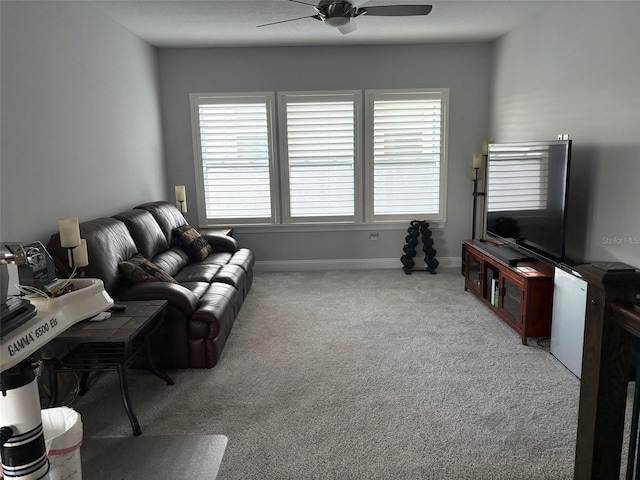 living room featuring carpet floors, baseboards, and a ceiling fan