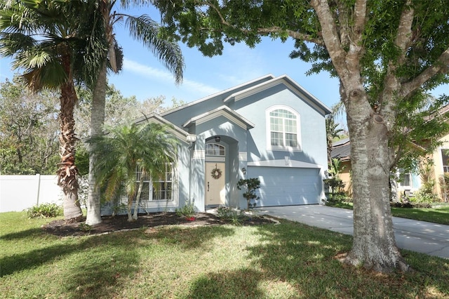 view of front of home with a garage, driveway, a front lawn, and stucco siding