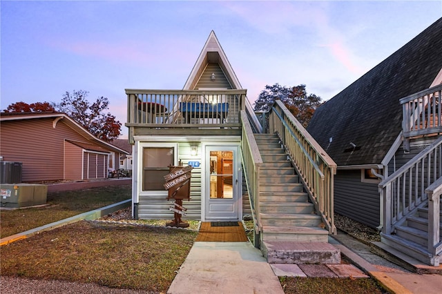 view of front of house with stairs and central AC