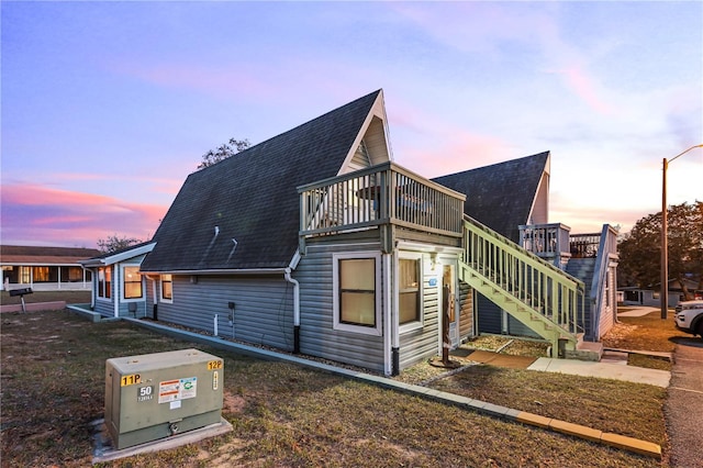 view of home's exterior featuring stairs and roof with shingles