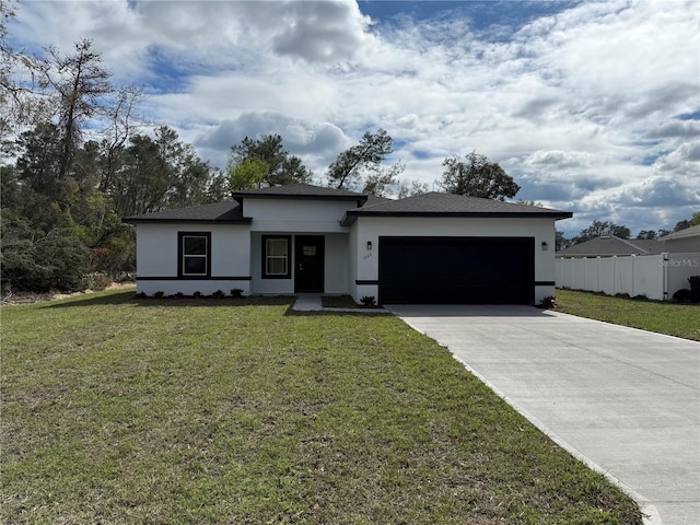 view of front of house featuring a front yard, an attached garage, and stucco siding