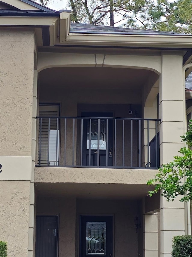 exterior space with a balcony and stucco siding