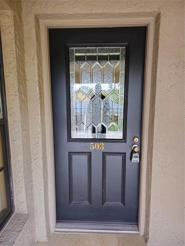 entrance to property featuring stucco siding