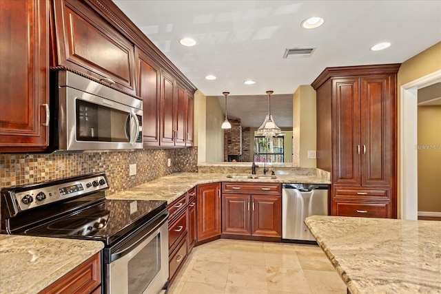 kitchen with visible vents, hanging light fixtures, decorative backsplash, appliances with stainless steel finishes, and a sink