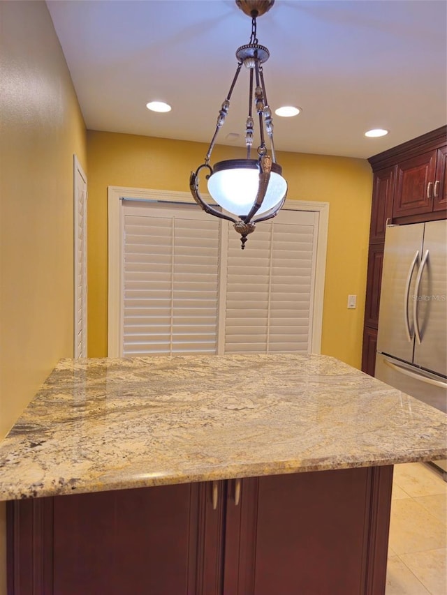 kitchen with light stone countertops, light tile patterned floors, recessed lighting, and stainless steel refrigerator