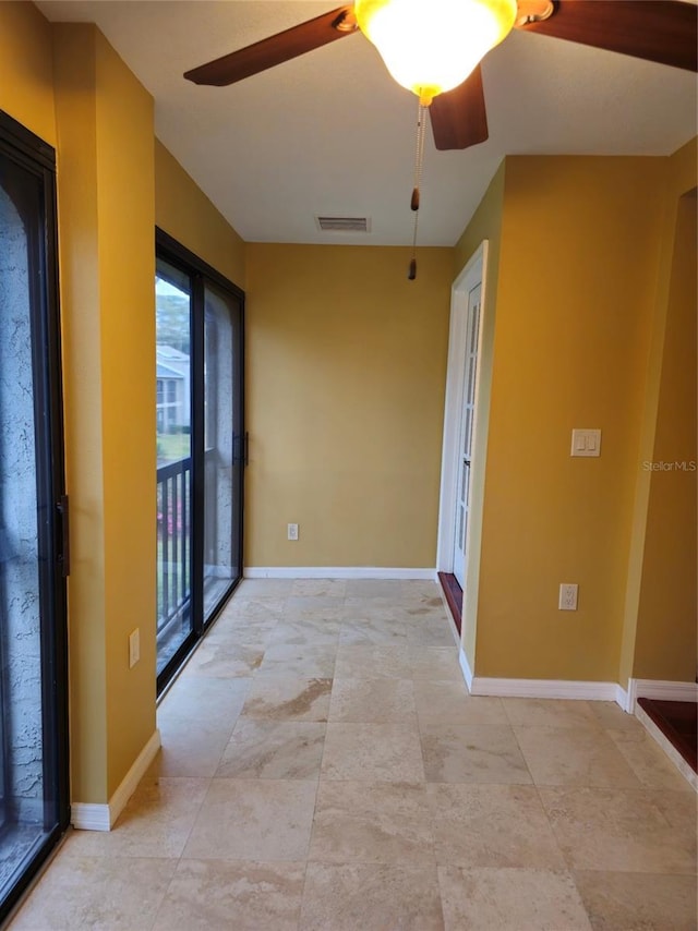 empty room with visible vents, ceiling fan, and baseboards