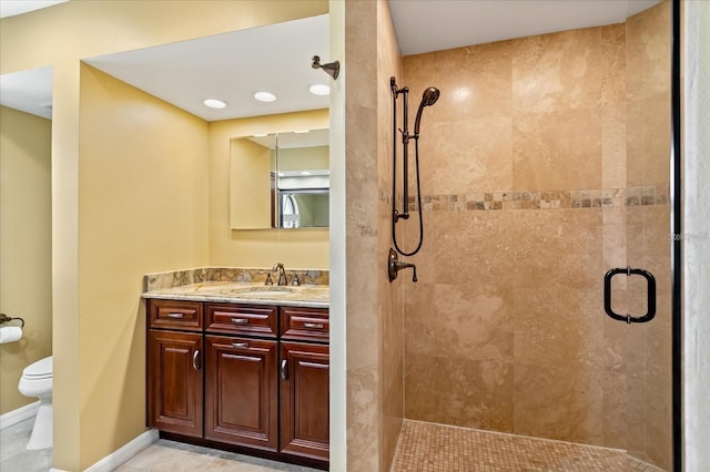 full bathroom featuring toilet, a stall shower, baseboards, and vanity