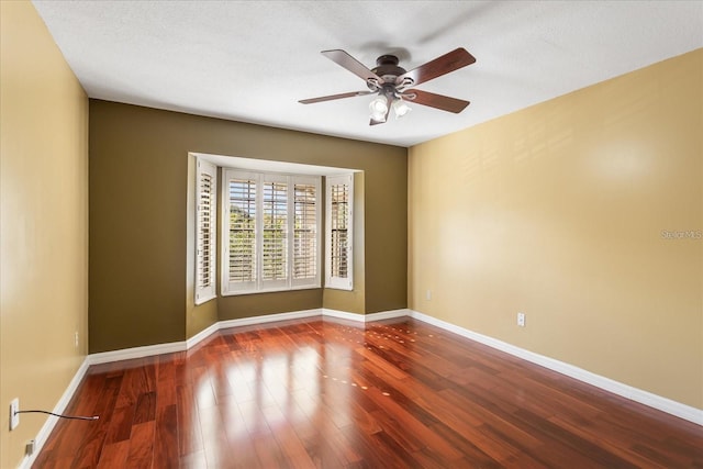 unfurnished room featuring ceiling fan, a textured ceiling, baseboards, and wood finished floors