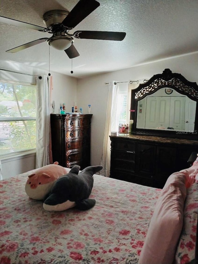 bedroom with a textured ceiling and ceiling fan