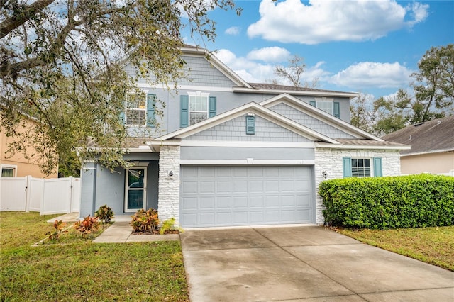 craftsman inspired home featuring concrete driveway, stone siding, a gate, fence, and a front yard