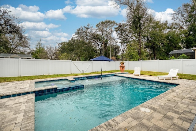 view of pool featuring a patio area, a fenced backyard, and a pool with connected hot tub