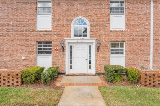 view of exterior entry with brick siding