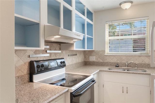 kitchen with white cabinets, electric range oven, backsplash, light countertops, and a sink
