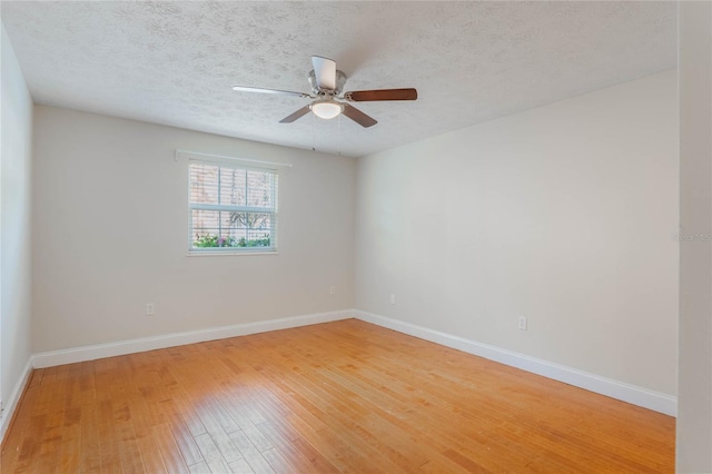 unfurnished room with light wood-style floors, a textured ceiling, and baseboards