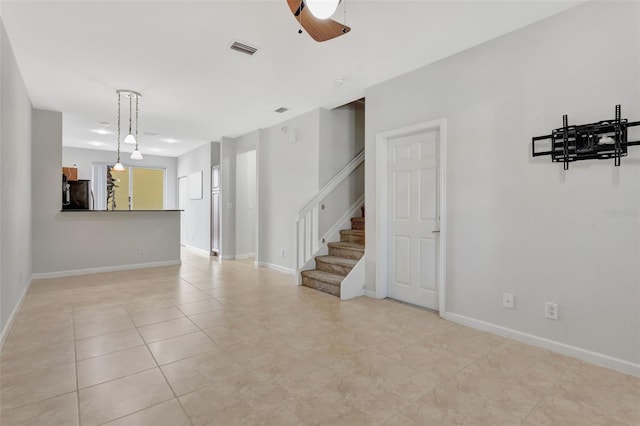 unfurnished living room featuring light tile patterned floors, stairway, visible vents, and baseboards